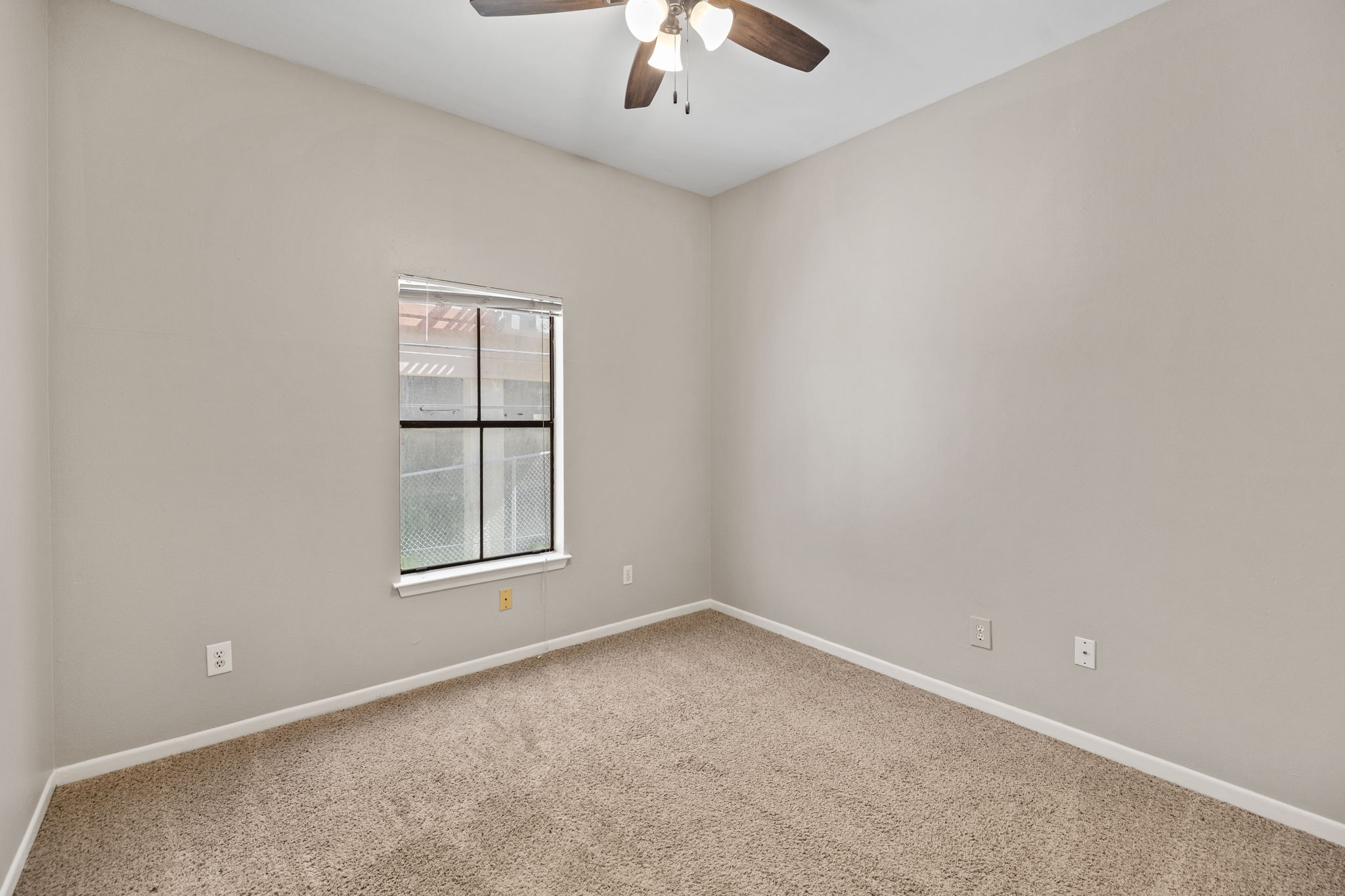 712 Graham Place, Unit 203 Austin, TX 78705 - Photo 20 of 30 an empty room with a window and a ceiling fan