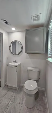a bathroom with a toilet a sink and mirror