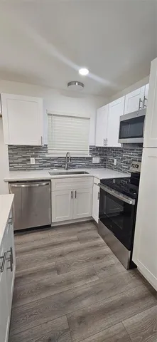 a kitchen with stainless steel appliances granite countertop a stove top oven a sink and cabinets