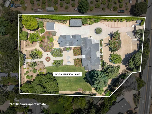 a large white kitchen with granite countertop lots of counter space and a sink