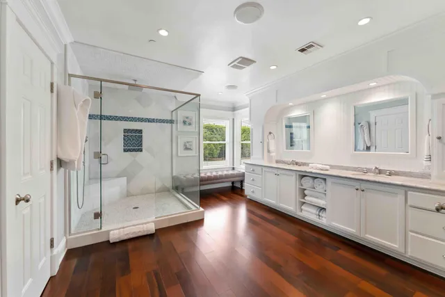 a view of a dining room and livingroom with furniture wooden floor a chandelier