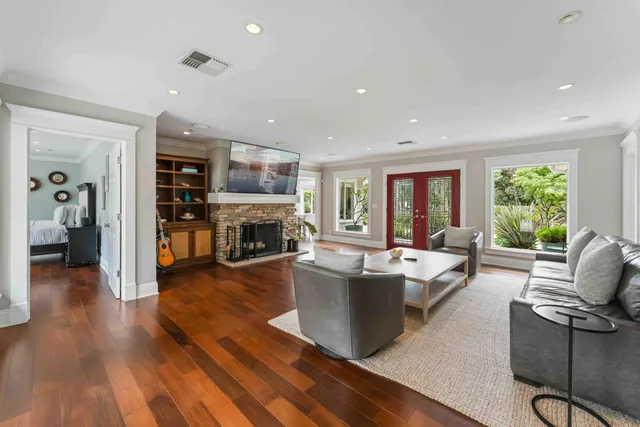 a dining room with wooden floor a chandelier a wooden table and chairs