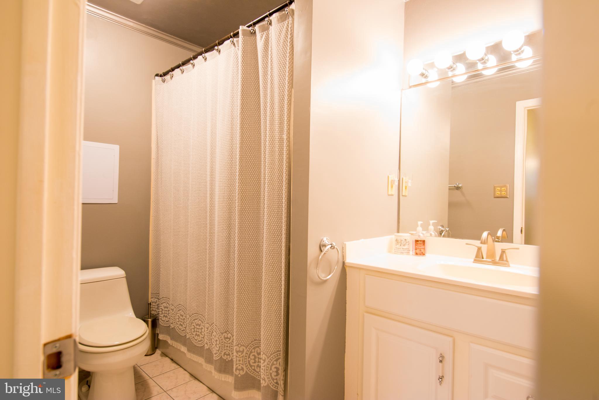 14211 Ansted Road Silver Spring, MD 20905 - Photo 19 of 27 a bathroom with a sink a toilet and a mirror