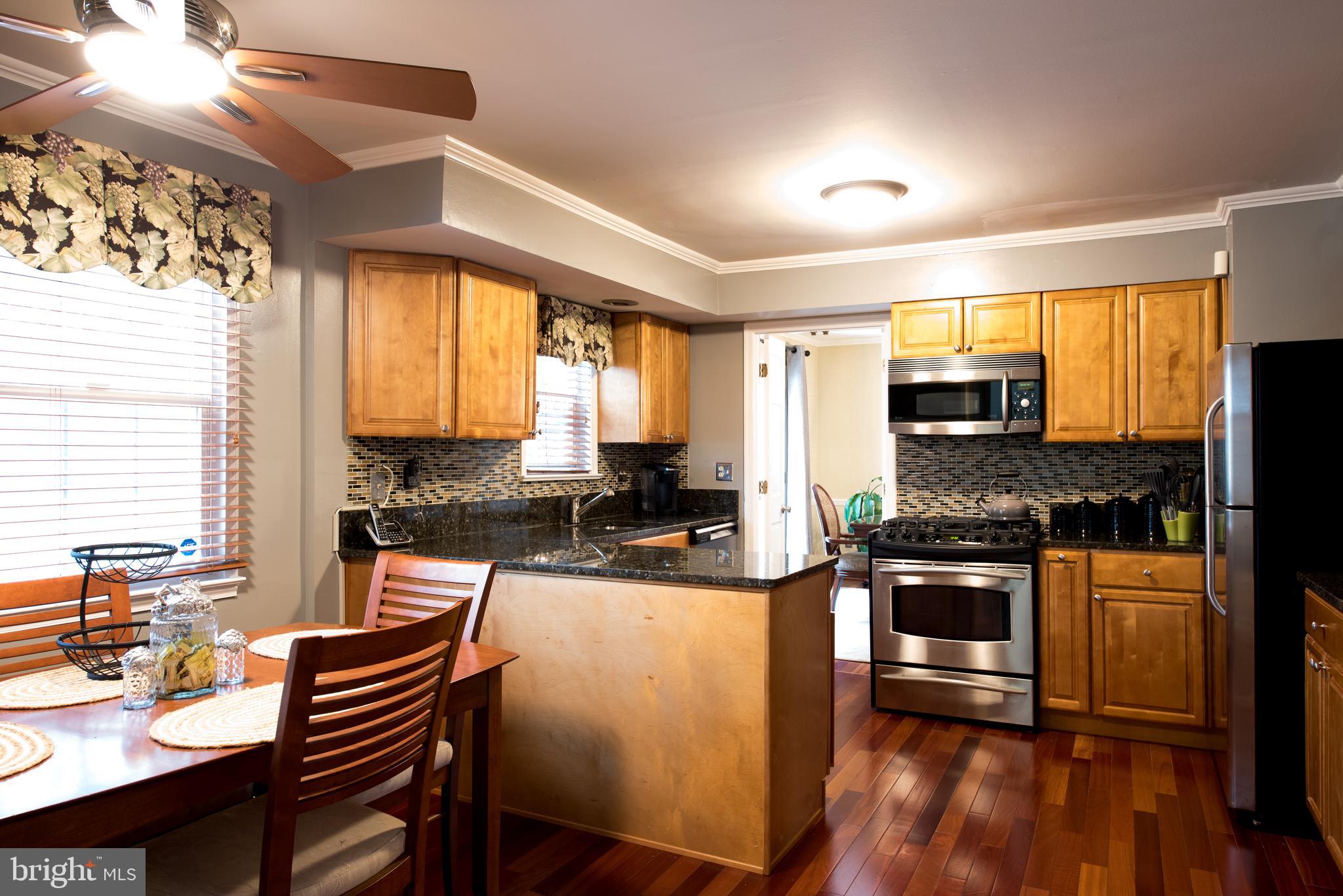14211 Ansted Road Silver Spring, MD 20905 - Photo 10 of 27 a kitchen with stainless steel appliances granite countertop sink stove top oven and cabinets