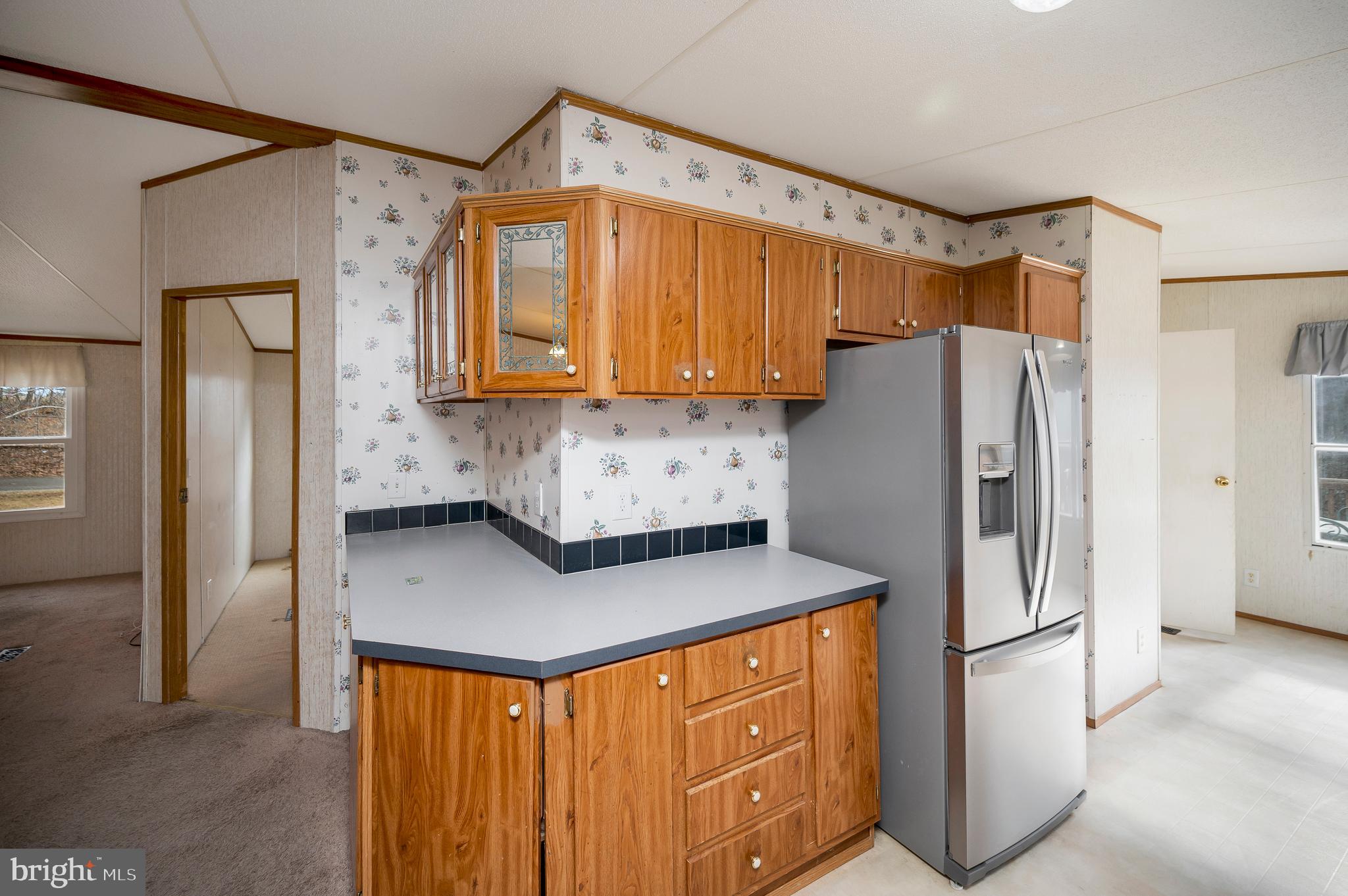 12619 Orange Plank Road Locust Grove, VA 22508 - Photo 23 of 43 a kitchen with stainless steel appliances a refrigerator a sink a stove and white cabinets