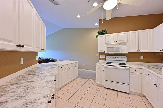 a kitchen with white cabinets and white appliances