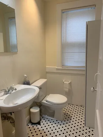 a kitchen with a sink a stove and white cabinets