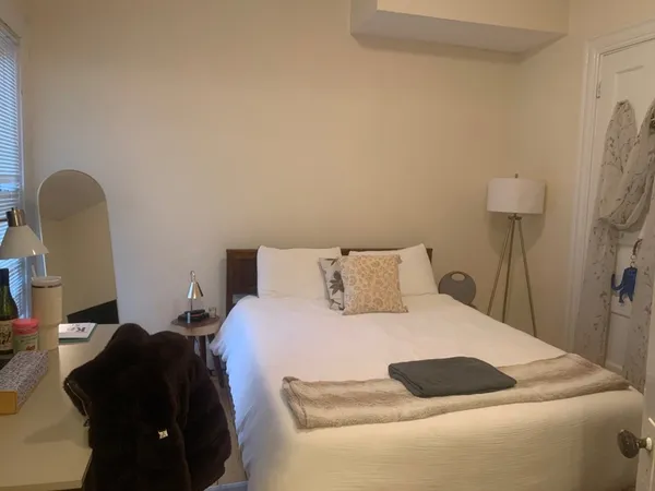 a bedroom with a bed and a refrigerator