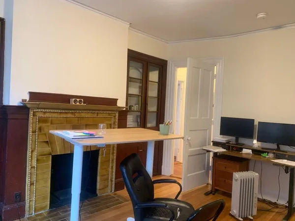 a bedroom with a bed and a refrigerator