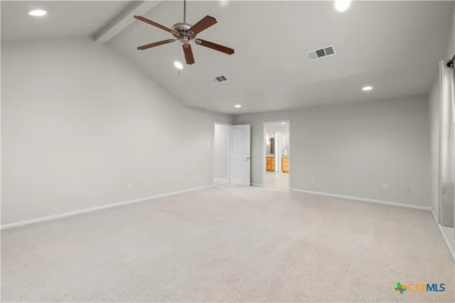 an empty room with ceiling fan and window