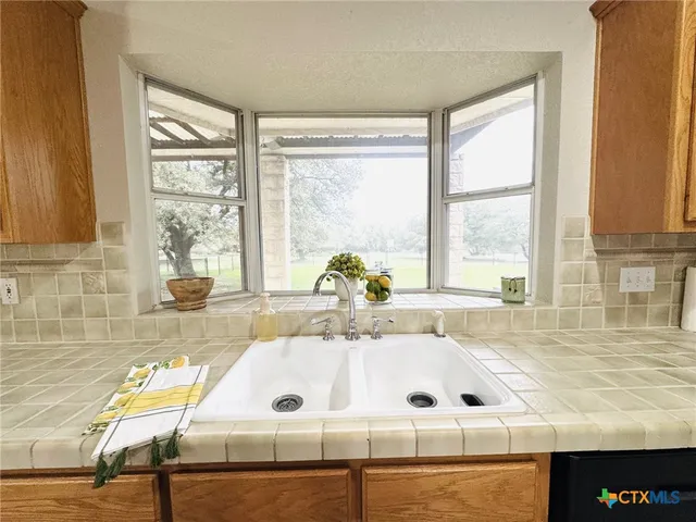 a bathroom with a tub a sink and a large window
