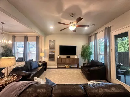 a living room with furniture a large window and a flat screen tv