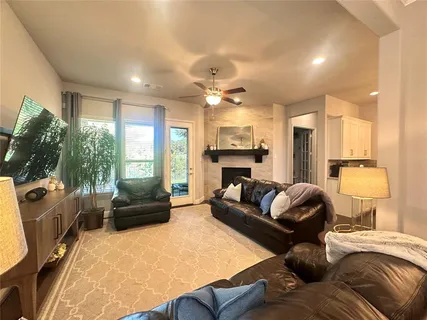 a living room with furniture kitchen view and a large window