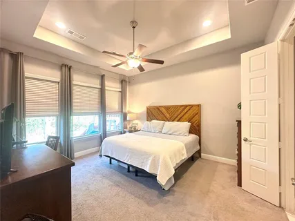 a spacious bedroom with a large bed and a chandelier