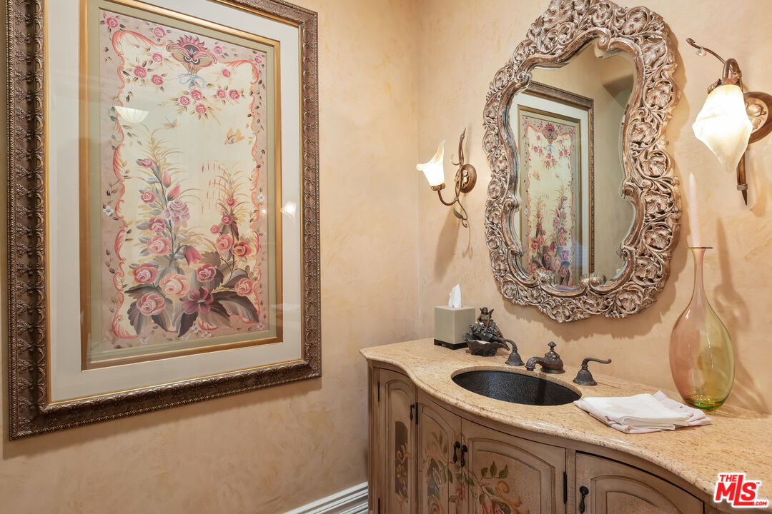 a bathroom with a sink and a mirror with painted walls