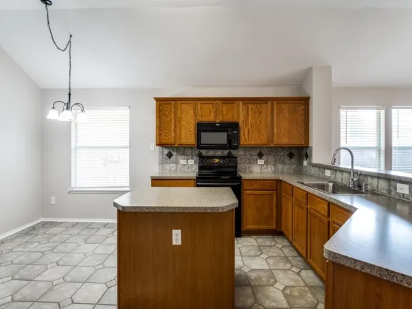 a kitchen with stainless steel appliances granite countertop a sink stove and microwave