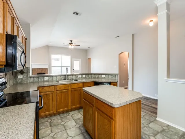 a kitchen with stainless steel appliances granite countertop a sink a stove counter space and cabinets