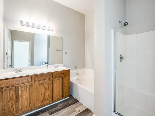 an empty room with wooden floor chandelier fan and windows