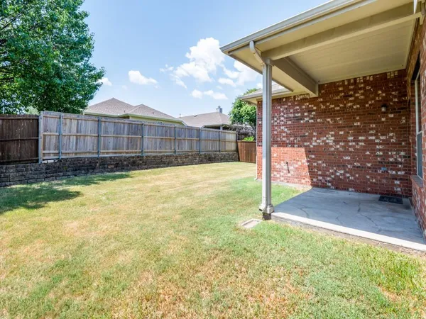 a view of a backyard with wooden fence