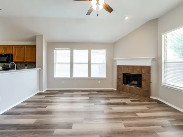 a view of an empty room with a window and fireplace