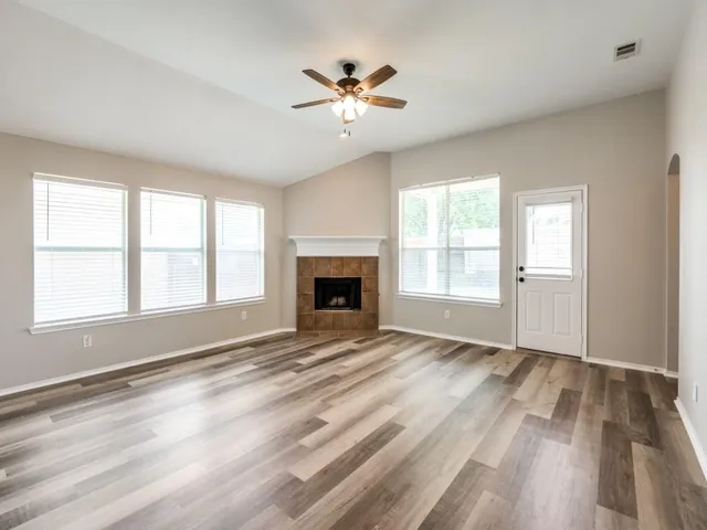 a view of an empty room with window and fireplace