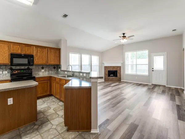 a view of an empty room with a fireplace and a window
