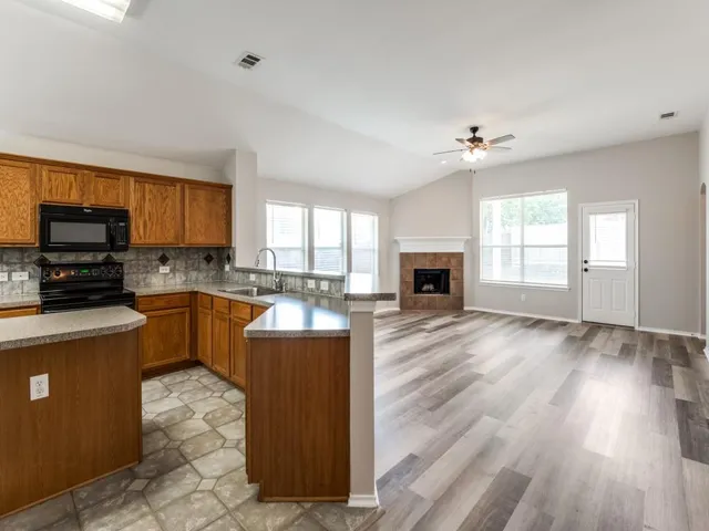 a view of an empty room with a fireplace and a window