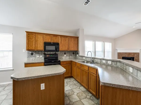 a kitchen with microwave a stove and cabinets