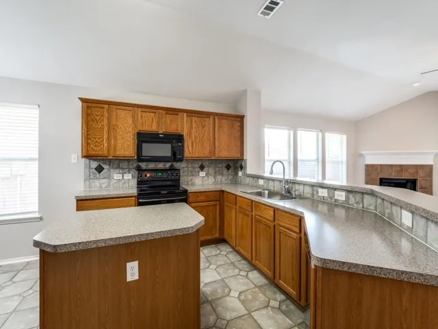 a kitchen with microwave a stove and cabinets