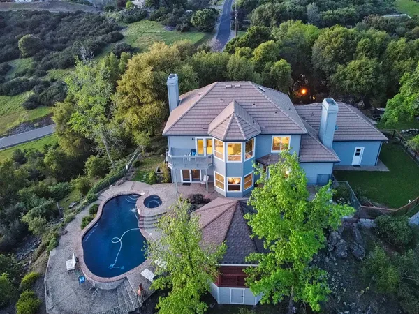 an aerial view of a house with garden space and a street view