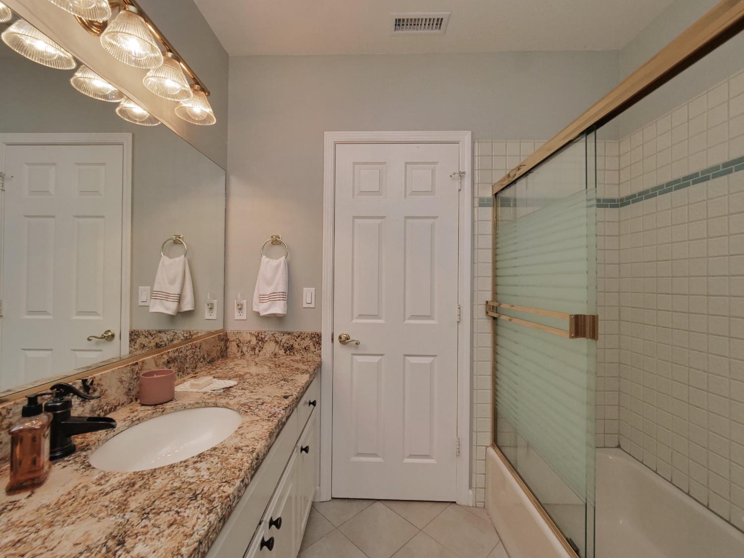 2405 Greensboro Road Placerville, CA 95667 - Photo 45 of 99 a bathroom with a granite countertop sink a mirror and shower