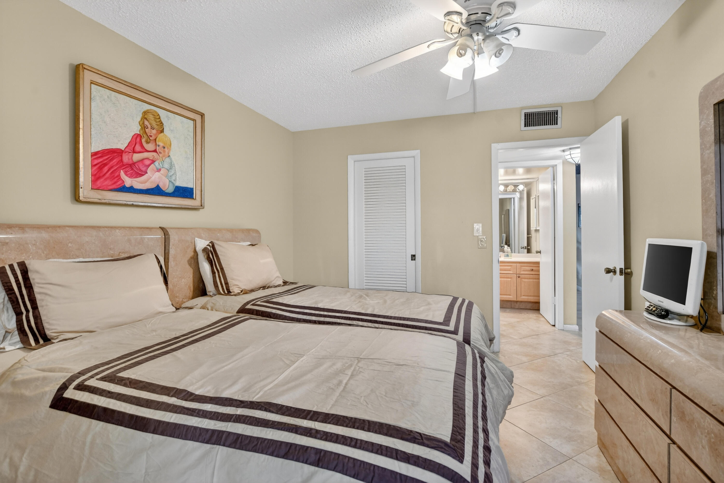 3009 Yarmouth C, Unit 3009 Boca Raton, FL 33434 - Photo 15 of 75 a bedroom with a bed and a flat screen tv