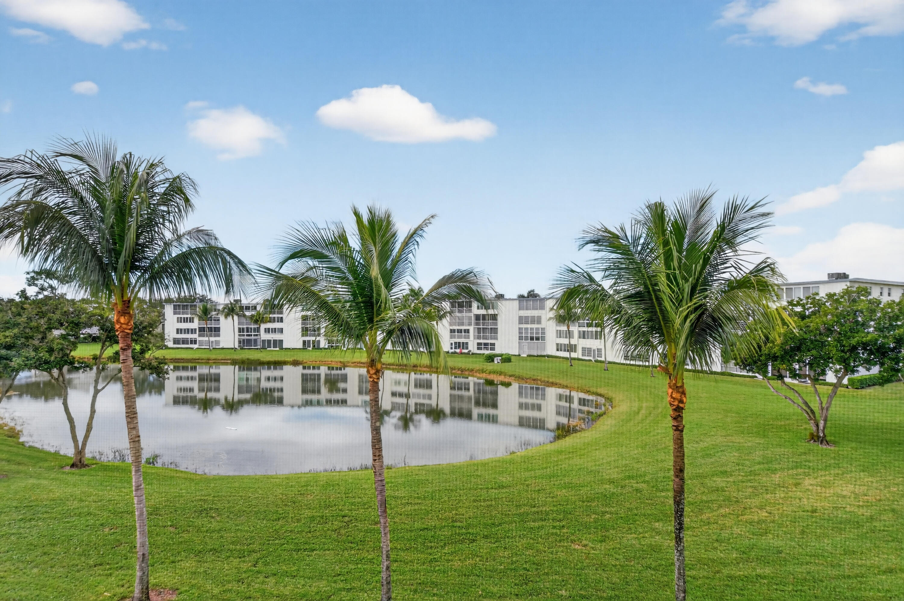 3009 Yarmouth C, Unit 3009 Boca Raton, FL 33434 - Photo 20 of 75 a view of swimming pool with a table and chairs