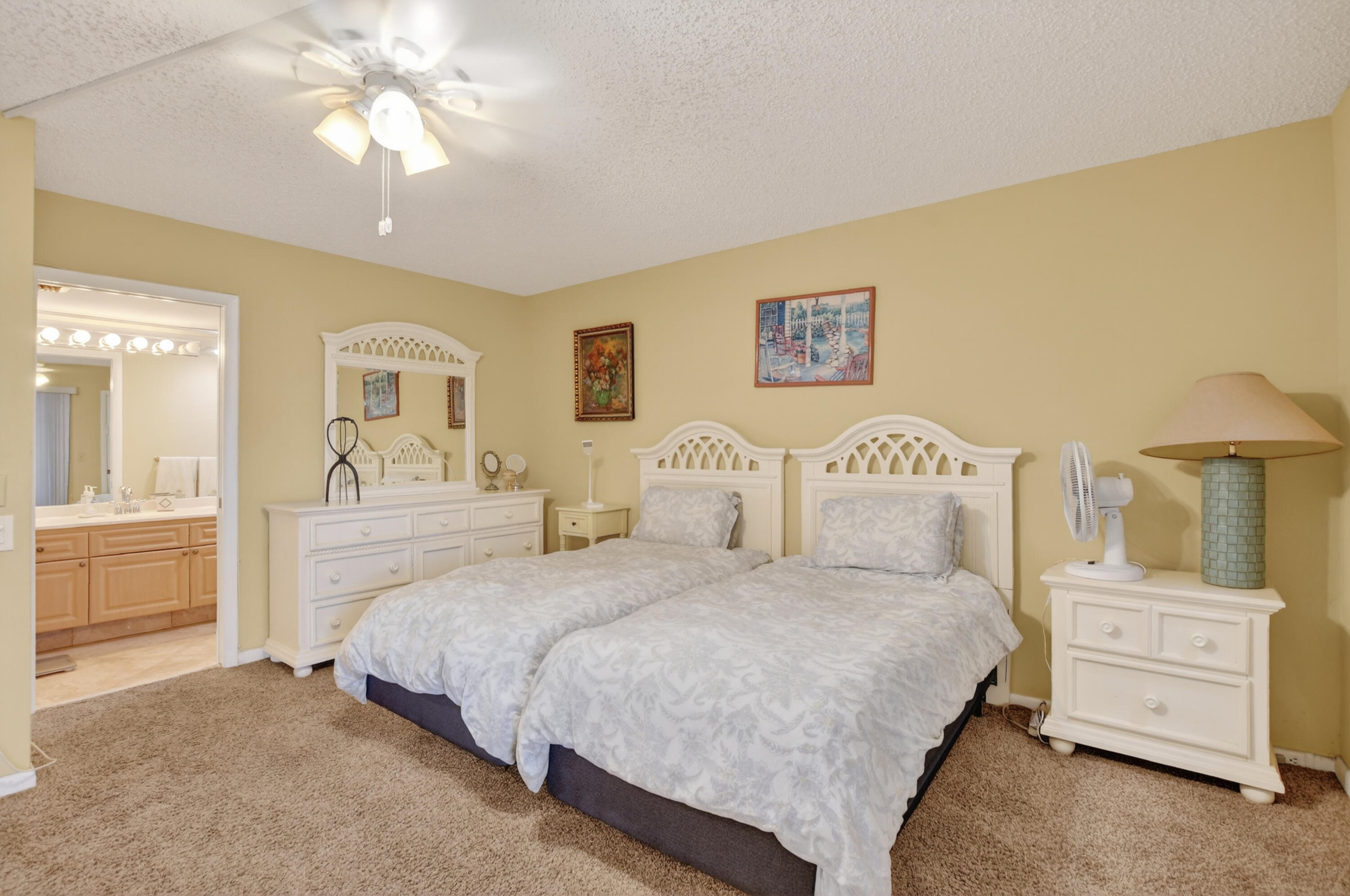 3009 Yarmouth C, Unit 3009 Boca Raton, FL 33434 - Photo 10 of 75 a bedroom with a large bed and a chandelier