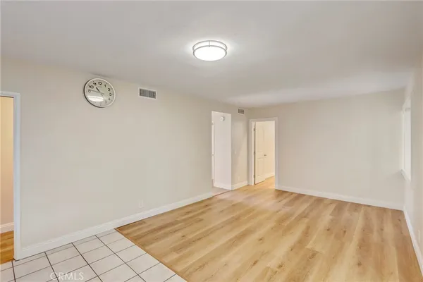 a living room with stainless steel appliances kitchen island a large counter top and a wooden floors