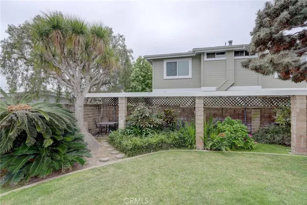 a view of a backyard with potted plants and a bench