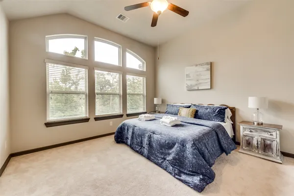 a spacious bedroom with a large bed and a large window