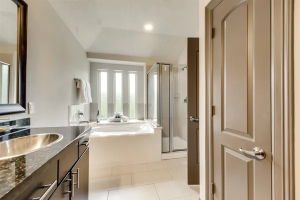 a room with a sink a mirror and a washer dryer