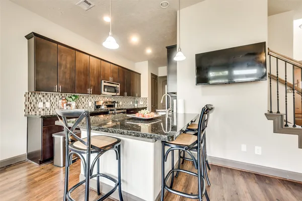 a kitchen with a table chairs refrigerator and microwave