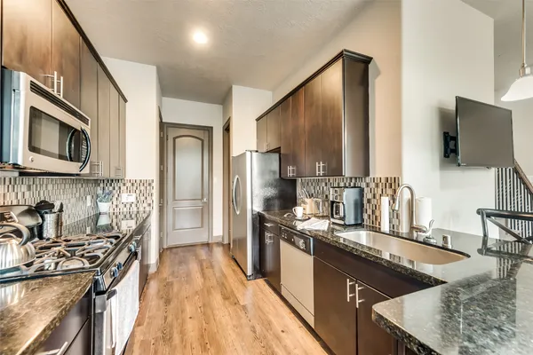a kitchen with stainless steel appliances granite countertop a sink stove and refrigerator