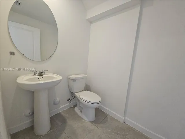 a bathroom with a sink toilet and a mirror