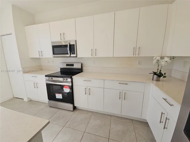 a kitchen with stainless steel appliances granite countertop white cabinets a sink and dishwasher