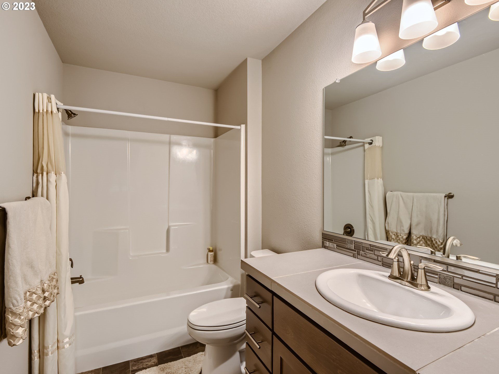 38439 Maple Street Sandy, OR 97055 - Photo 27 of 34 a bathroom with a granite countertop sink a toilet a mirror and shower