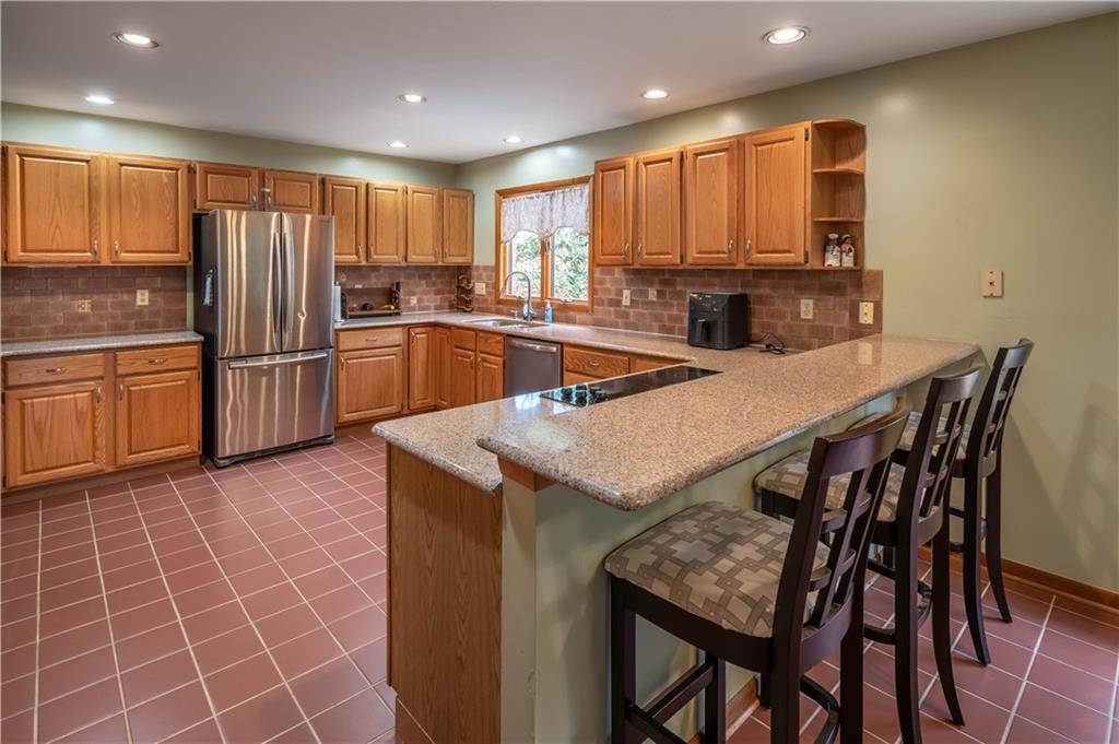970 Braddock Road Pittsburgh, PA 15221 - Photo 7 of 25 a kitchen with stainless steel appliances granite countertop a table chairs sink refrigerator and microwave