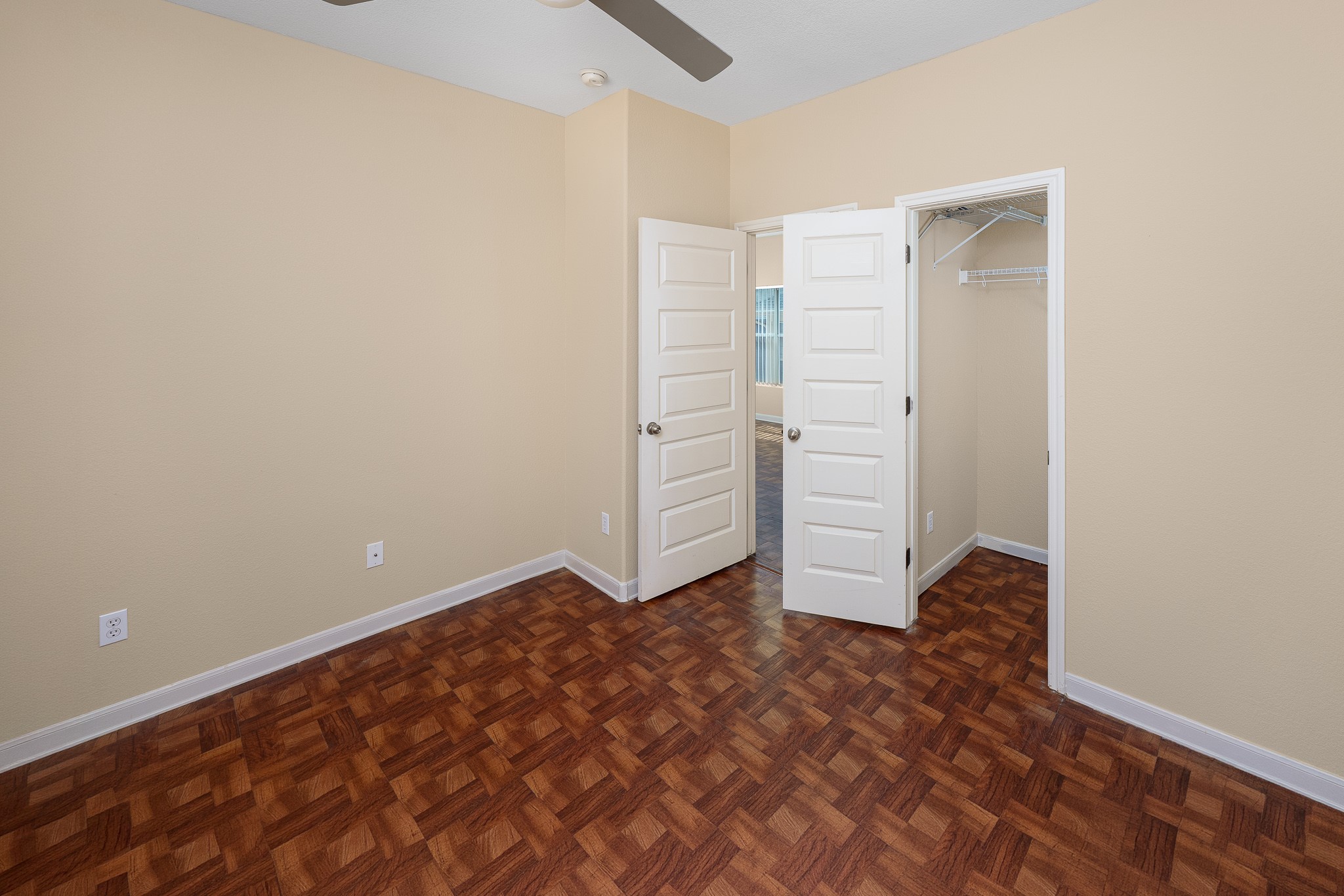 2829 Saville Loop, Unit 17C Austin, TX 78741 - Photo 10 of 28 A comfortable bedroom features warm-toned walls, rich wood flooring, and a convenient closet.