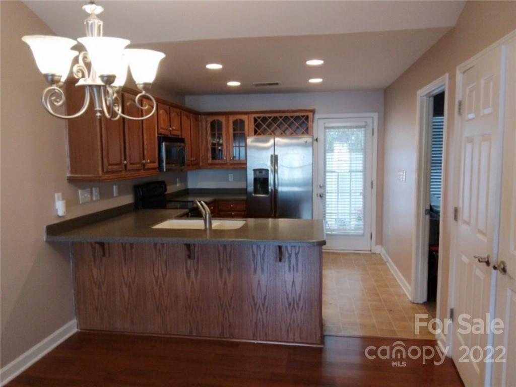 1921 Sandal Brook Road Indian Land, SC 29707 - Photo 4 of 7 a view of a kitchen with granite countertop a stove top oven a sink and dishwasher with wooden floor