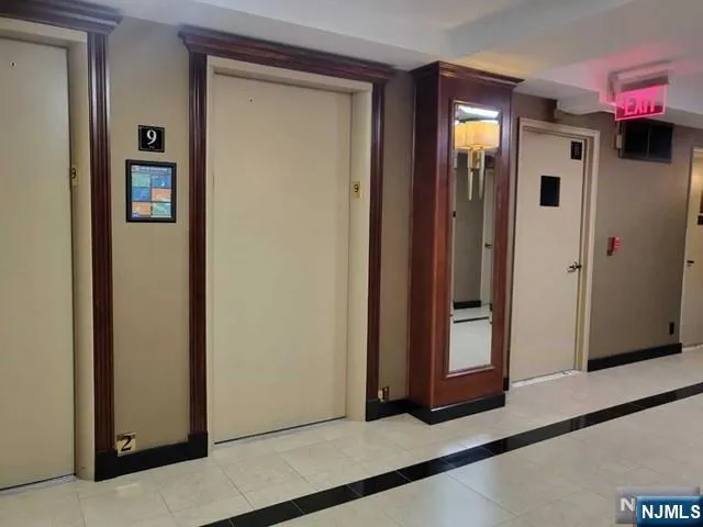 a view of a hallway with wooden floor and closet