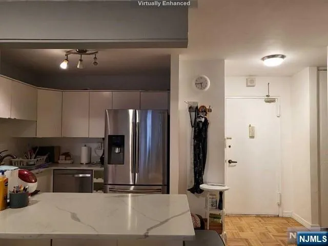 a kitchen with stainless steel appliances granite countertop a refrigerator and a stove