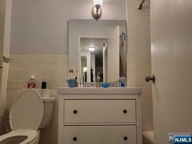 a bathroom with a toilet a sink and mirror