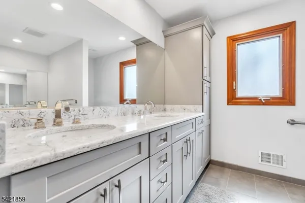 a view of an empty room with wooden floor and a ceiling fan